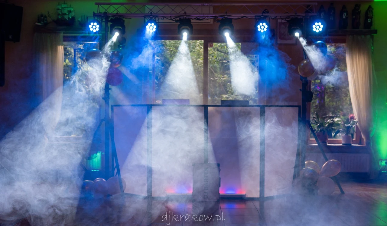 Eleganckie białe stanowisko DJ-a z profesjonalnym nagłośnieniem i oświetleniem